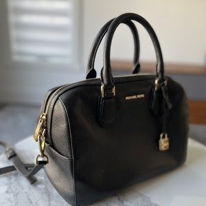 Michael Kors black leather handbag with strap.